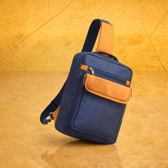 Nomad Blu sling bag on yellow backdrop Nomad Blu sling bag on yellow backdrop